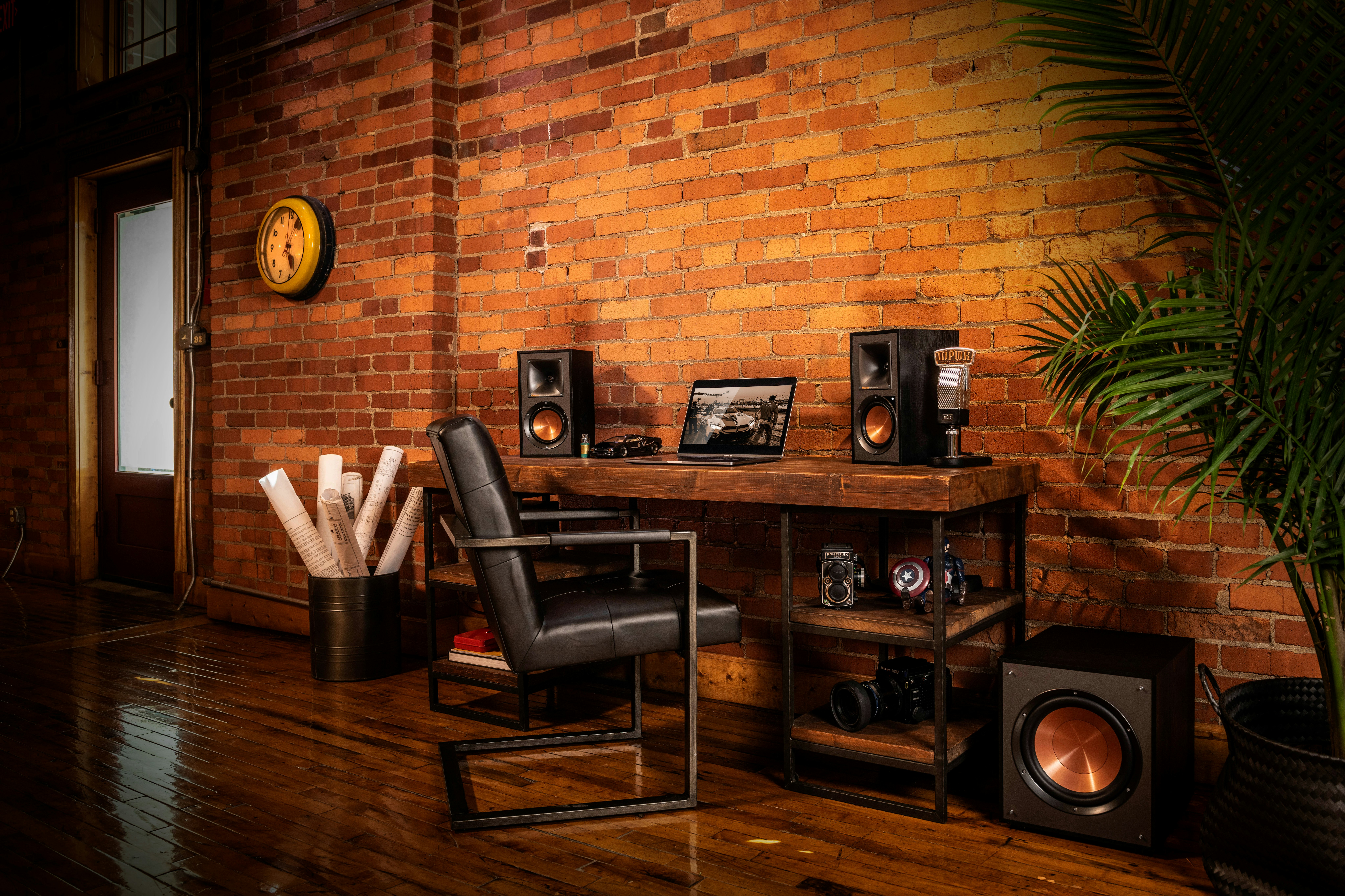 Altavoces potenciados Klipsch Reference sobre un escritorio con una computadora portátil